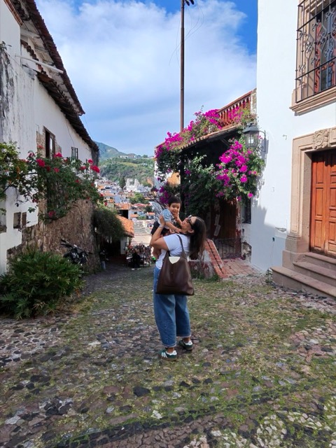 Kenia con su hijo en una calle empedrada de Taxco